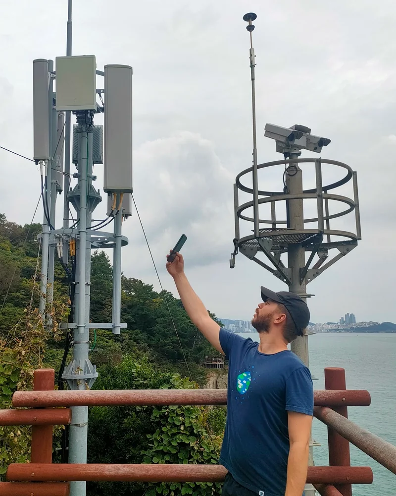 Boris Nachbaur collant son téléphone contre une antenne 5G à l'étranger